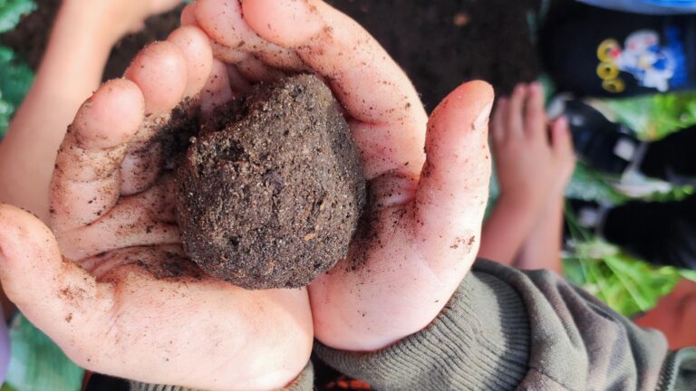 Ein Kind hält eine Kugel Erde in der Hand