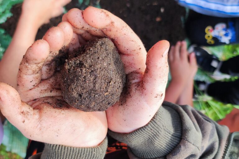 Ein Kind hält eine Kugel Erde in der Hand