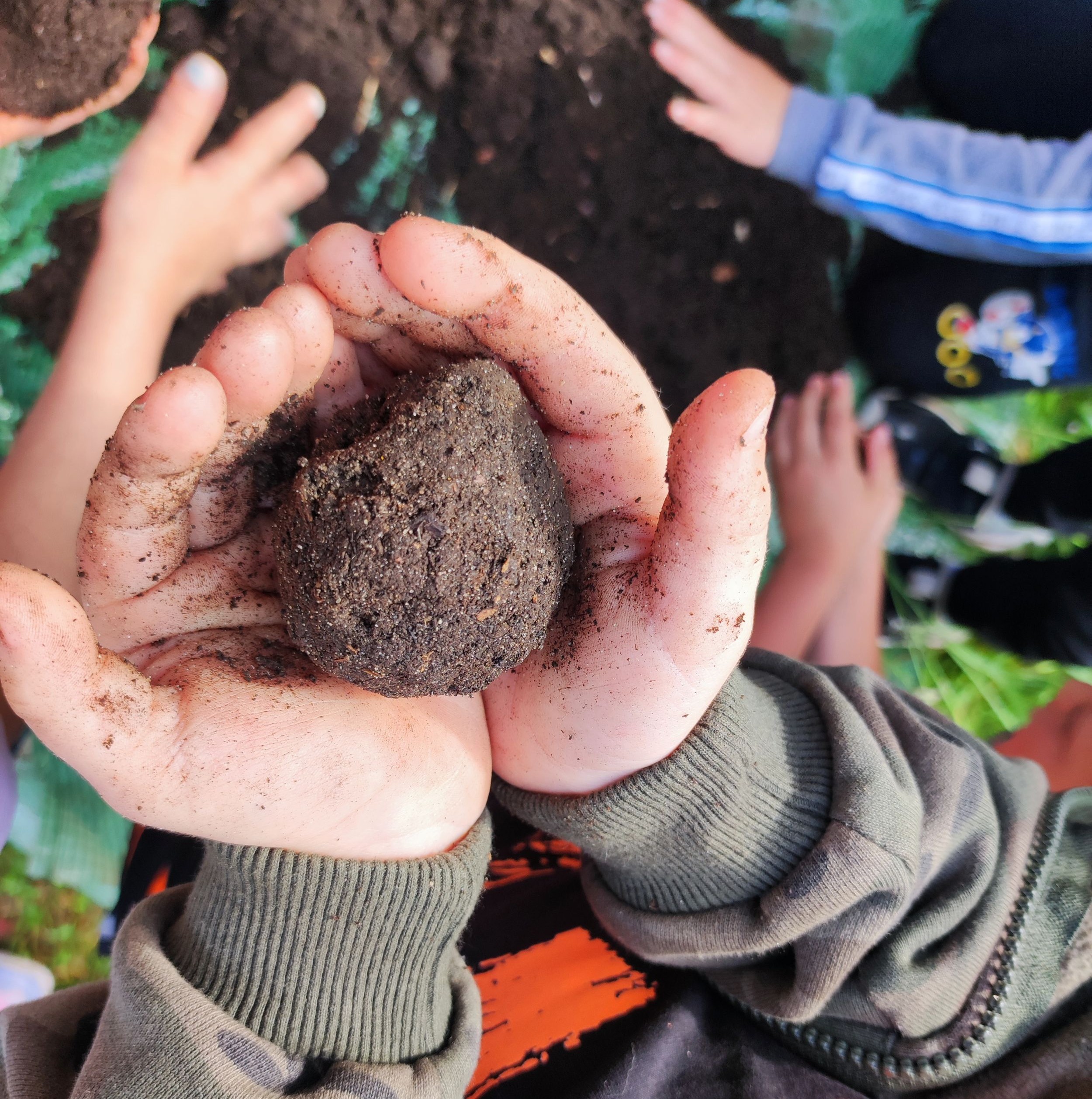 Kugel Kompost Hand Kinder 095004 Ein Kind hält eine Kugel Erde in der Hand